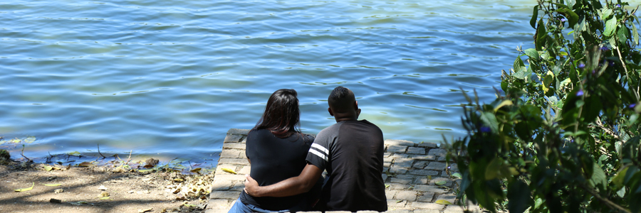 Duas pessoas sentadas apreciam o lago no Parque Cidade de Toronto